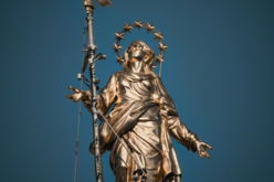 Golden statue of a woman against a blue sky